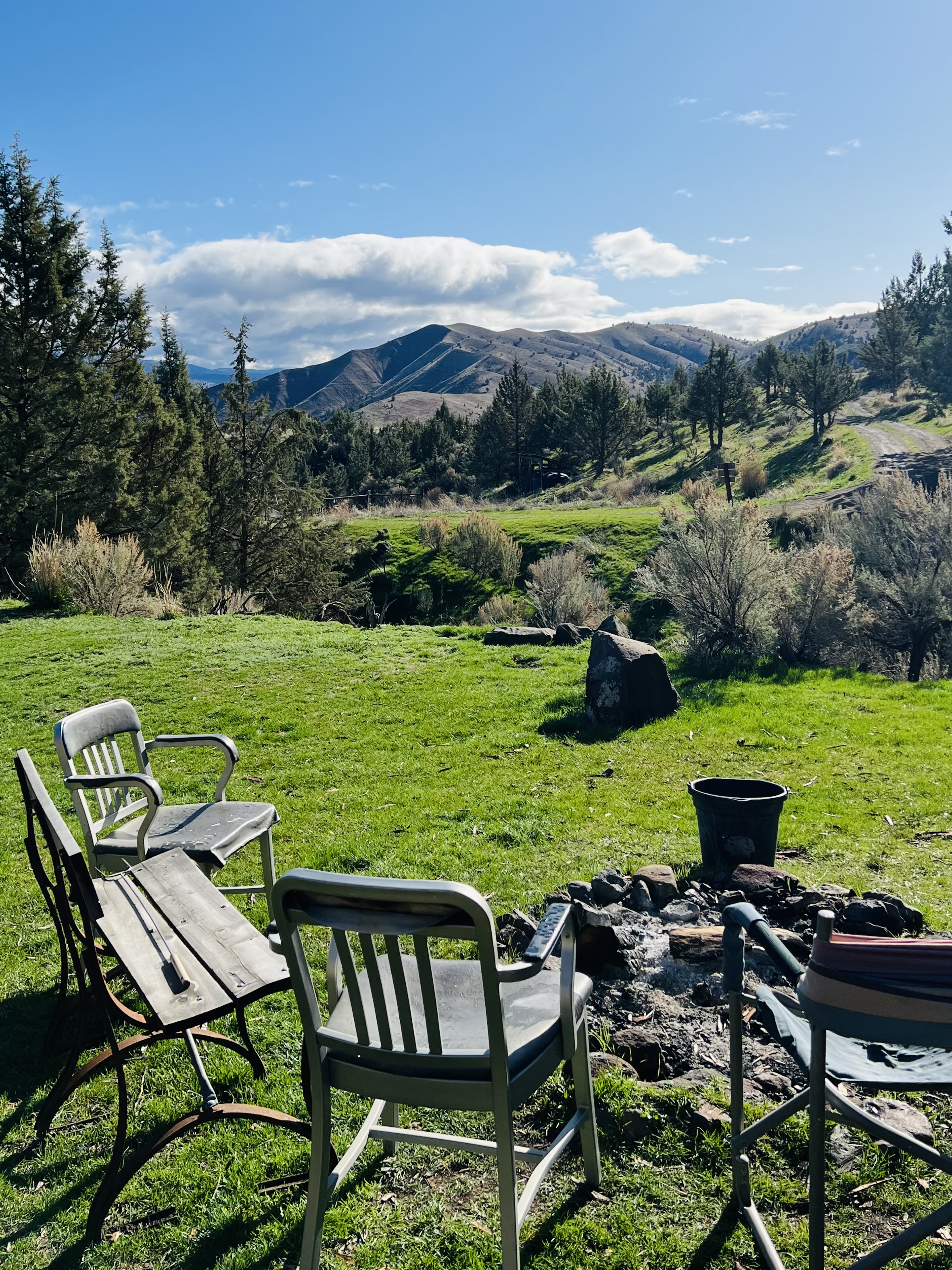 Wooden cabin at Guyon Springs Inn in Dayville Oregon with grass and chair on the front porch