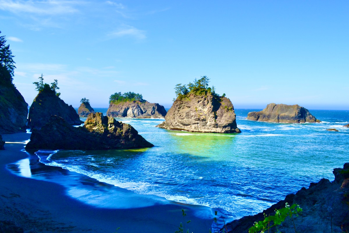 Secret Beach Oregon at low tide showing the cove, basalt sea stacks, and Miller Creek waterfall in Samuel H. Boardman State Scenic Corridor near Brookings