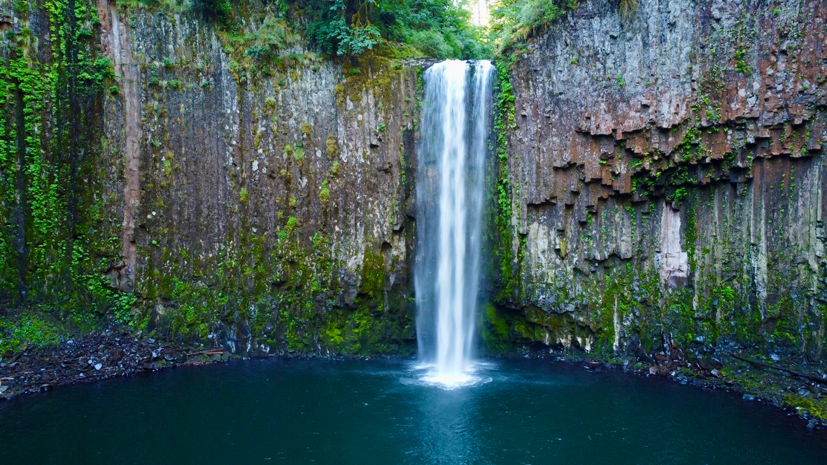 Abiqua Falls cascading down a curved basalt amphitheater into a green pool surrounded by mossy cliffs in the Oregon Cascade foothills