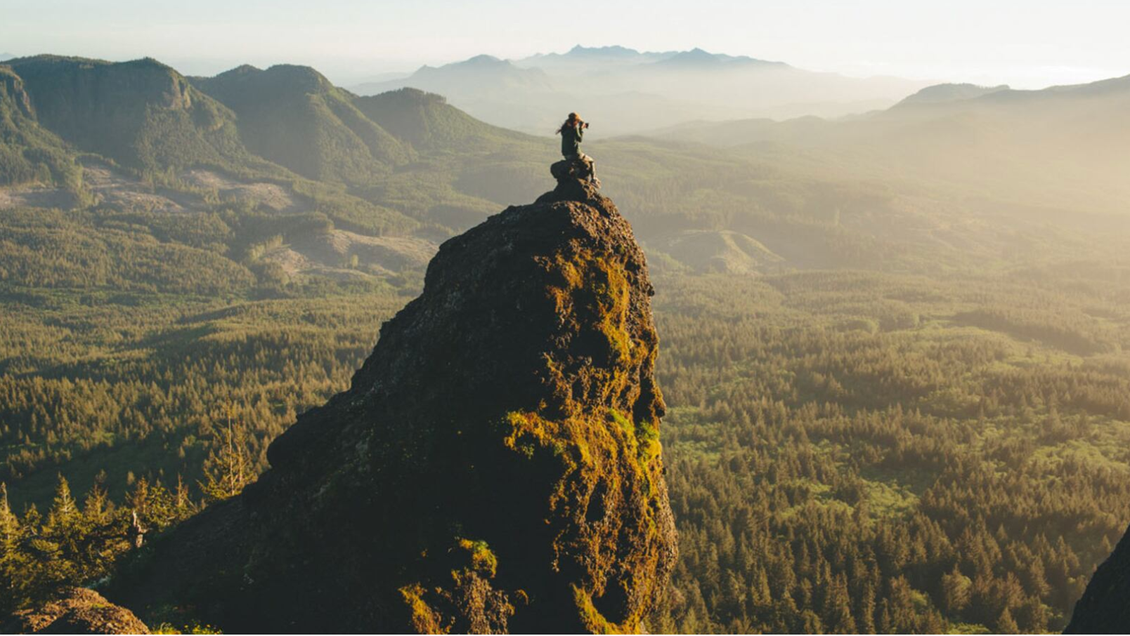 Saddle Mountain Trail aerial photograph with a hiker on the peak of saddle mountain and the valley and forest below in the background