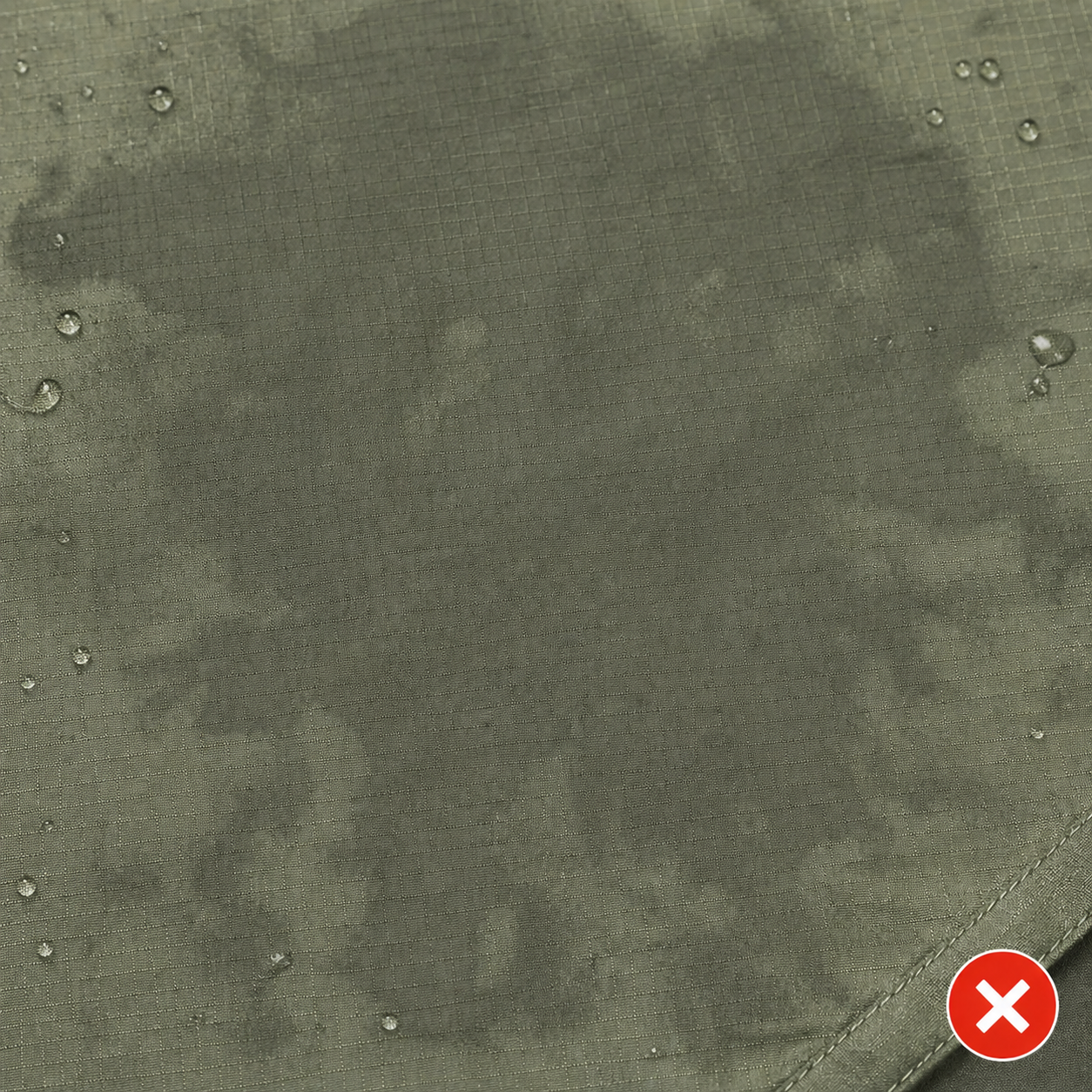 Tent rainfly fabric with failed DWR coating: water has soaked into the fabric (called wetting out), creating visibly darker patches where the surface no longer beads water