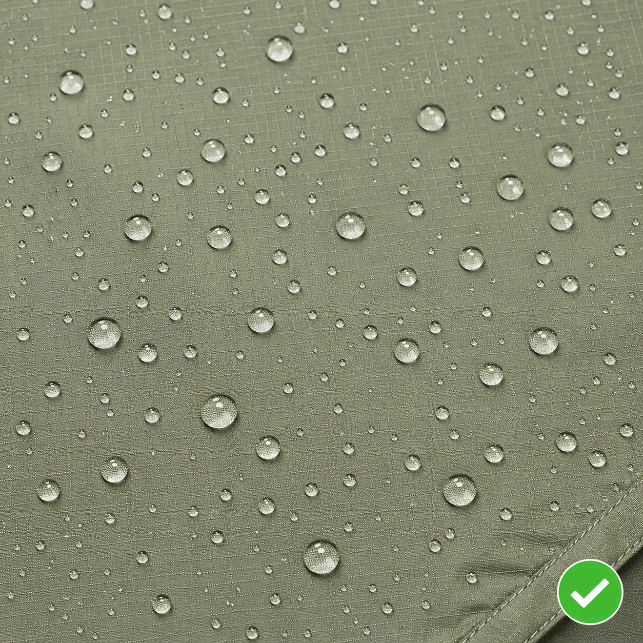 Tent rainfly fabric with intact DWR coating: water beads up in perfect droplets and rolls off the surface, fabric color unchanged underneath