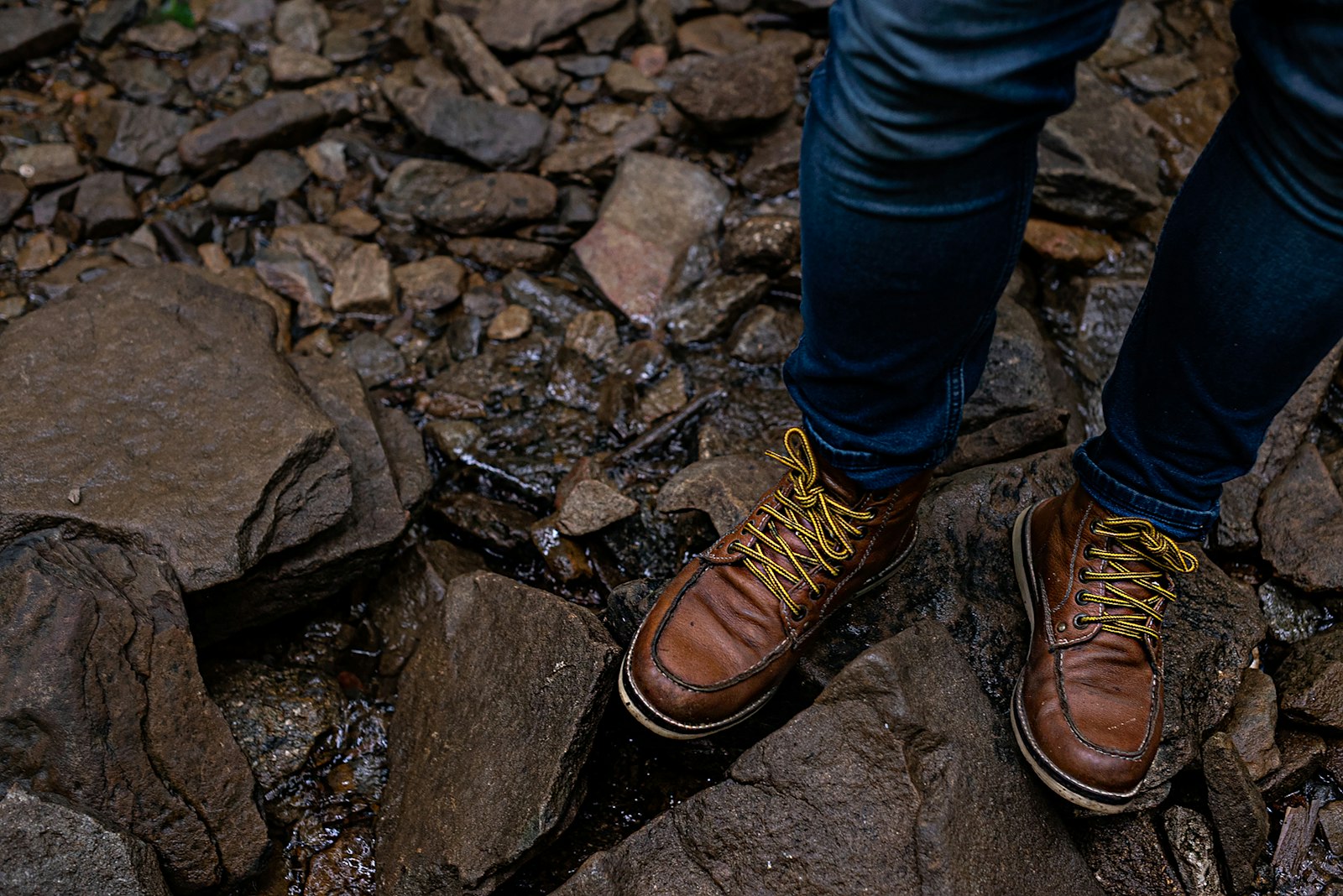 A pair of leather hiking boots, freshly waterproofed and treated, sitting on a wooden surface