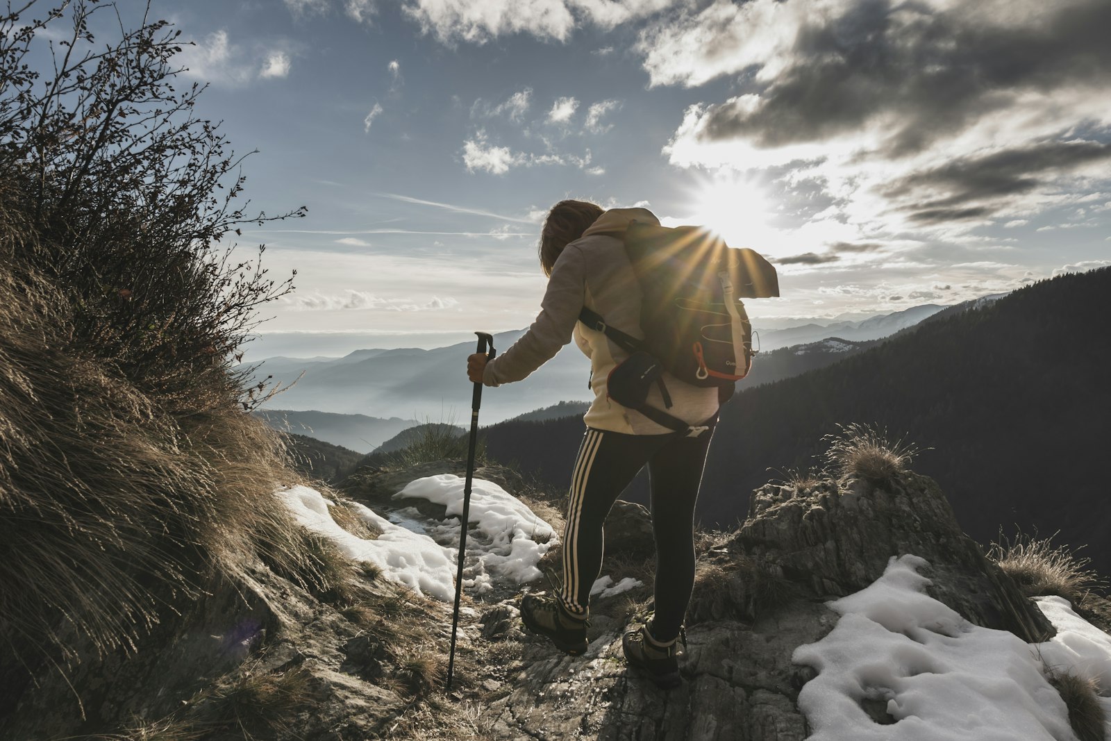 Backpacker with trekking poles on an Oregon trail, covering multi-day routes across the state